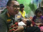 kapolresta-balikpapan-kombes-pol-turmudi-beserta-istrinya-ny-tina-turmudi-menggendong-balita.jpg
