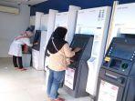 nasabah-bank-mandiri-tengah-melakukan-transaksi-keuangan-di-atm-bank-mandiri.jpg
