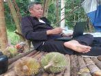 seorang-warga-menikmati-sensasi-liburan-di-kebun-durian-bersama-keluarga-di-oku.jpg