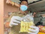 petugas-menunjukan-barang-temuan-berupa-tahu-kuning-dan-kembang-pacar-yang-mengandung.jpg
