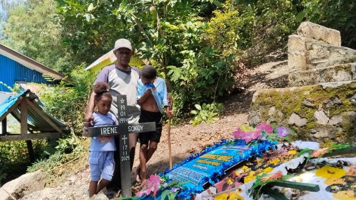 DARURAT KESEHATAN DI PAPUA - Abraham Kabey berfoto bersama kedua anak Irene Sokoy dan Niel Kabey di makam Irene Sokoy di Kampung Hobong, Distrik Sentani, Kabupaten Jayapura, Papua.