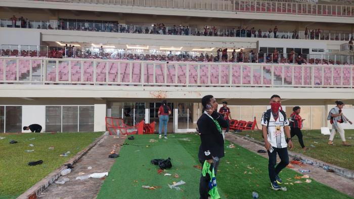 RICUH LAGA PERSIPURA - Kondisi terkini di Stadion Lukas Enembe, Jayapura, Papua, Jumat (8/5/2026) malam. Tampak panitia pelaksana berdiri menyaksikan kerusakan fasilitas pasca-ricuh suporter lantaran kecewa Persipura kalah atas Adhyaksa FC 0-1. Mereka lalu merusak berbagai fasilitas pertandingan, termasuk bench dandinding kaca gedung.
