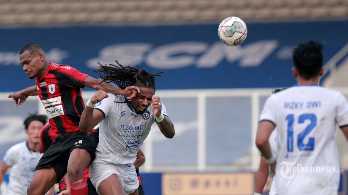 pesepak-bola-arema-fc-jersey-putih-berebut-bola-dengan-pesepak-bola-persipura-jayapura.jpg
