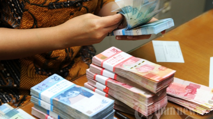 seorang-karyawan-saat-menghitung-mata-uang-rupiah.jpg