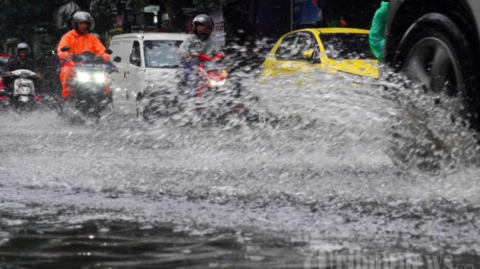 Kendaraan bermotor melintasi banjir cileuncang yang menggenangi permukaan Jalan Cibaduyut Raya, Kota Bandung, Jawa Barat, Jumat (16/2/2024).  (TRIBUN JABAR/GANI KURNIAWAN)