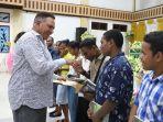 Paulus-Waterpauw-membagikan-buku-kepada-anak-anak-jemaat-GPDP-Logos-Sanggeng.jpg