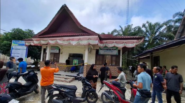 Warga menyaksikan Satreskrim Polres Siak melakukan olah TKP di kantor desa Dosan, kecamatan Pusako, kabupaten Siak, pasca-ditemukannya penjaga malam terluka parah, Kamis (23/4/2026).