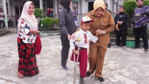 Bupati-Siak-Afni-membantu-salah-seorang-murid-SDN-04-Bungaraya.jpg