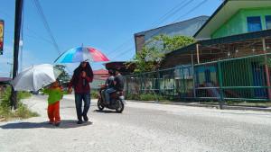 Warga-menggunakan-payung-untuk-menghindari-panas-pekanbaru.jpg