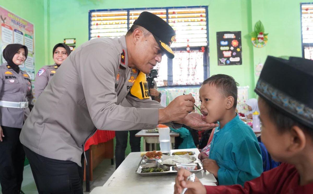 Wakapolda-Riau-Brigjen-Pol-K-Rahmadi-ikut-menyuapi-siswa-SD.jpg