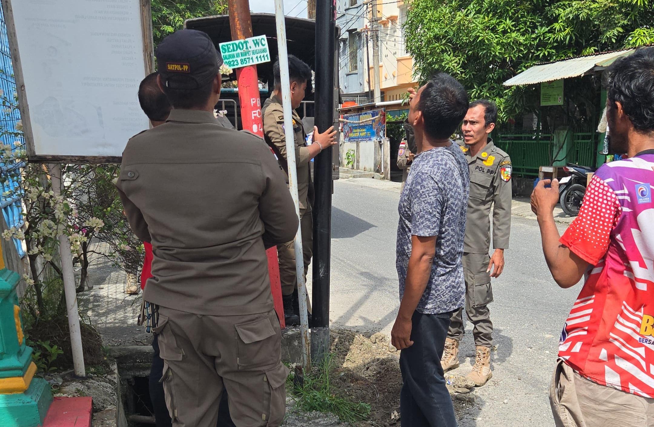 warga-dan-satpol-pp-bongkar-tiang-kabel-FO-di-Jalan-Kapur-Kota-Pekanbaru.jpg