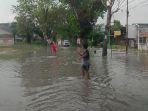 Anak-anak-memandu-pengendara-di-Jalan-Srikandi-Pekanbaru-yang-digenangi-air.jpg
