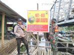Anggota-Polisi-dan-TNI-memasang-spanduk-peringatan-nuaya-di-rohil.jpg