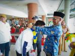 Kepala-SKO-Riau-Aslim-SPd-MPd-mengalungkan-bunganya-buat-atlet-pelajar-Riau.jpg