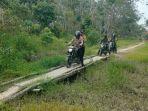 Para-personel-polres-pelalawan-melewati-jalan-setapak-di-hutan.jpg