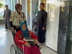 Seorang-petugas-menggiring-pasien-untuk-jalani-perawatan-ke-RSD-Madani-Pekanbaru.jpg