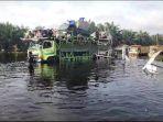 Truk-trado-mengangkut-mobil-motor-menyeberangi-banjir-di-Jalintim.jpg