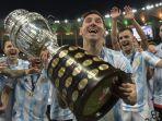 pemain-argentina-lionel-messi-memegang-trofi-saat-ia-merayakan-dengan-rekan-setimnya.jpg