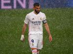 penyerang-real-madrid-karim-benzema-berjalan-di-tengah-hujan.jpg
