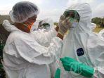 petugas-mengenakan-masker-dan-hazmat-suit.jpg
