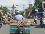 pria-naik-motor-membawa-jenazah-di-atas-beronjong.jpg