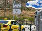 sebuah-taxi-melintas-di-samping-bendera-israel-di-kota-nablus.jpg