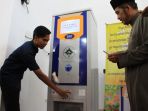 seorang-karyawan-cv-ta-karya-menunjukkan-bagaimana-cara-kerja-atm-beras_20181005_071953.jpg