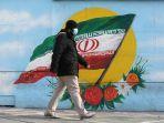 seorang-pria-berjalan-sambil-mengenakan-masker-di-ibu-kota-iran-teheran.jpg
