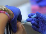 seorang-wanita-menerima-dosis-vaksin-covid-19.jpg