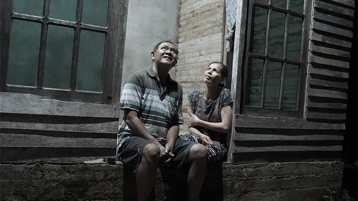 MENATAP HARU - Eka Susanti salah satu penerima manfaat Program Light Up The Dream (LUTD) di Desa Rasau Jaya Tiga, Kubu Raya, bersama sang suami, menatap haru cahaya lampu yang kini menerangi rumah mereka. 