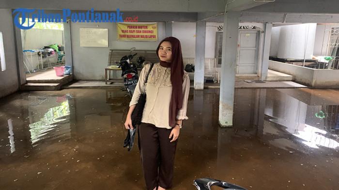 GENANGAN AIR - Siti Hatijah, Mahasiswa FKIP Untan saat berada di area parkir kosnya, Jumat 17 Oktober 2025. Terlihat area tersebut tergenang air.