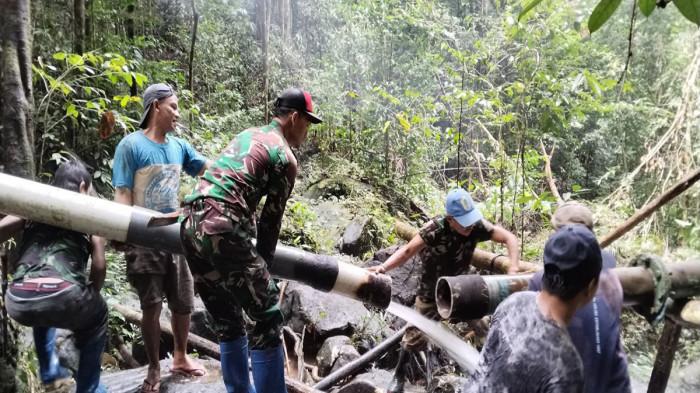 GOTONG ROYONG - TNI dan Masyarakat Kecamatan Puring Kencana, saat bergotong royong, memperbaiki pipa air bersih, dimana sudah seminggu ini masyarakat perbatasan Indonesia-Malaysia di Kabupaten Kapuas Hulu, sulit untuk mendapatkan air bersih, Selasa 3 Februari 2026. Dijelaskan Camat Badau, untuk mendapatkan air bersih, masyarakatnya biasanya ada yang beli air bersih dari tangki milik warga.