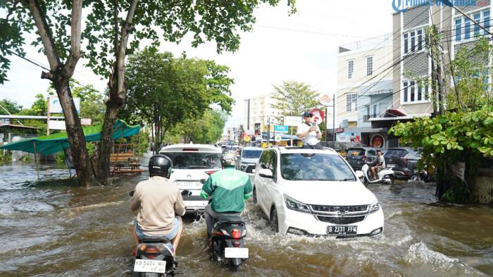 BANJIR ROB PONTIANAK - Tampak sejumlah masyarakat melintasi jalanan yang terendam banjir, di Kawasan Jalan Purnama, Pontianak Selatan, Kota Pontianak, Selasa 16 Juni 2026. Banjir disebabkan curah hujan dan resapan air tidak mampu menampung air hujan.