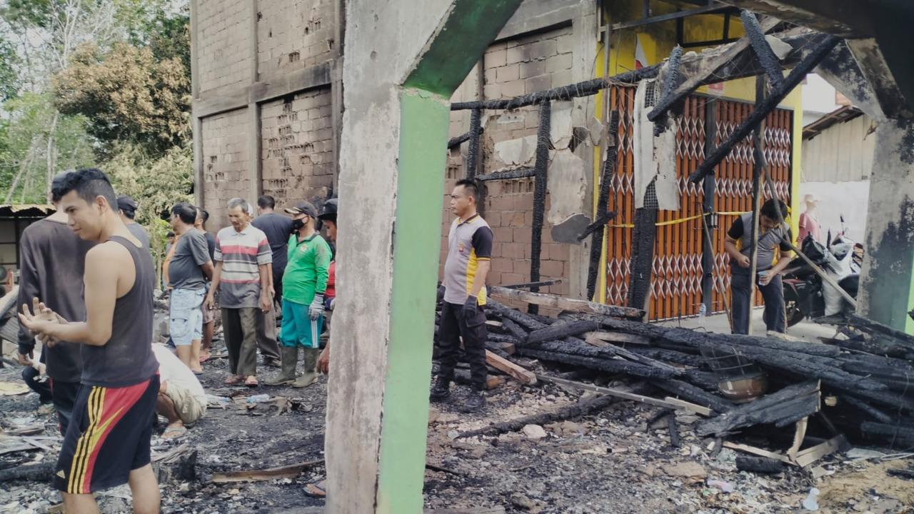 Personel Polsek Ledo Bersama Warga Bersihkan Bekas Kebakaran Ruko di Desa Lesabela