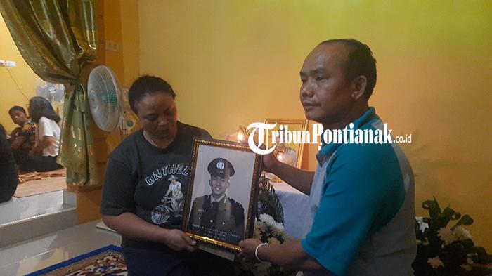 Inosensia-dan-suaminya-Y-Pandi-menunjukan-foto-Bripda-Ignatius-Dwi-Frisco-Sirage-rde.jpg