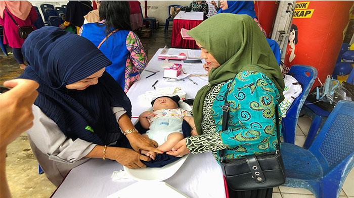 Petugas-posyandu-menimbang-dan-mengukur-tinggi-anak.jpg