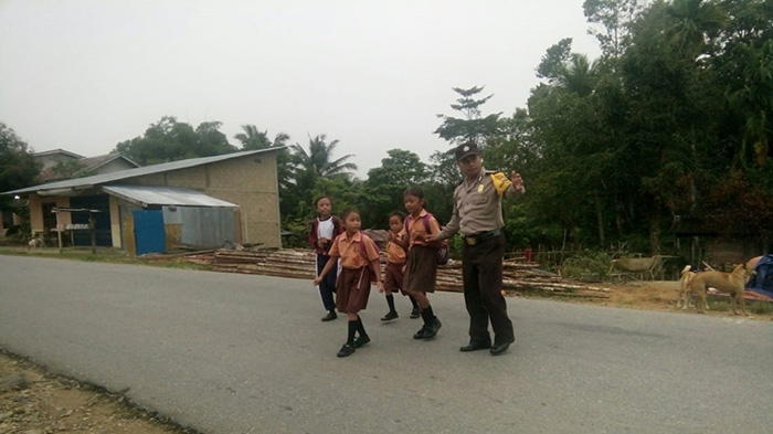 aiptu-rudiyanto-bhabinkamtibmas-polsek-lumar-saat-membantu-anak-sekolah-menyebrang-jalan.jpg