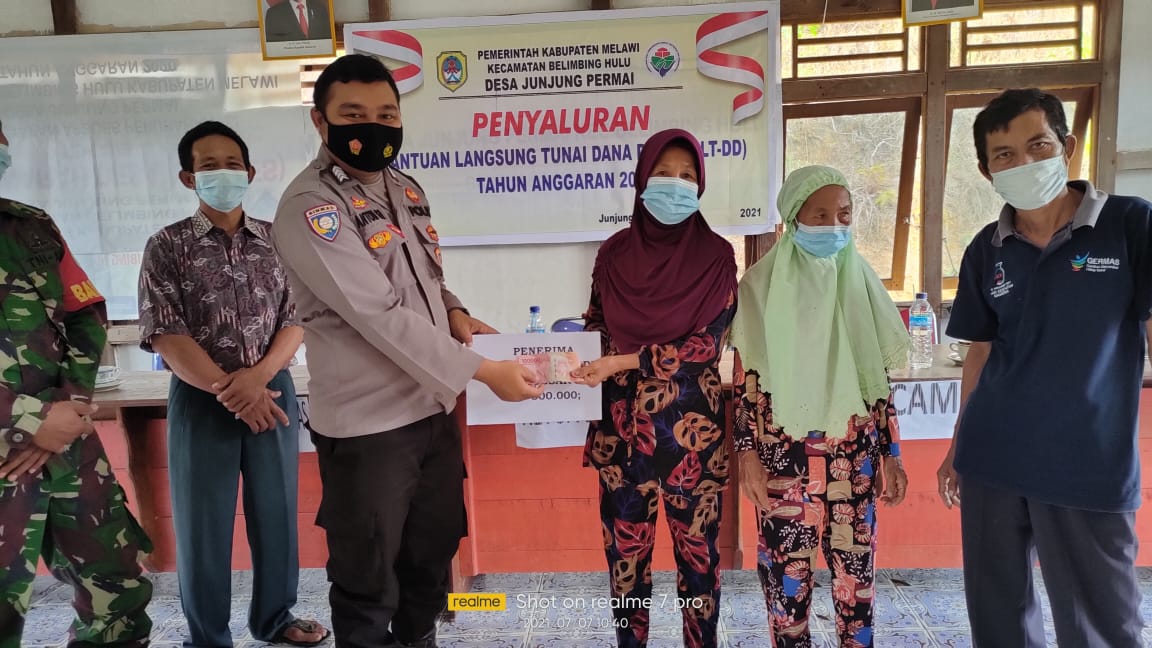 Bripka Anton Bagikan Masker Saat Kegiatan Pembagian BLT-DD di Desa Tanjung Permai