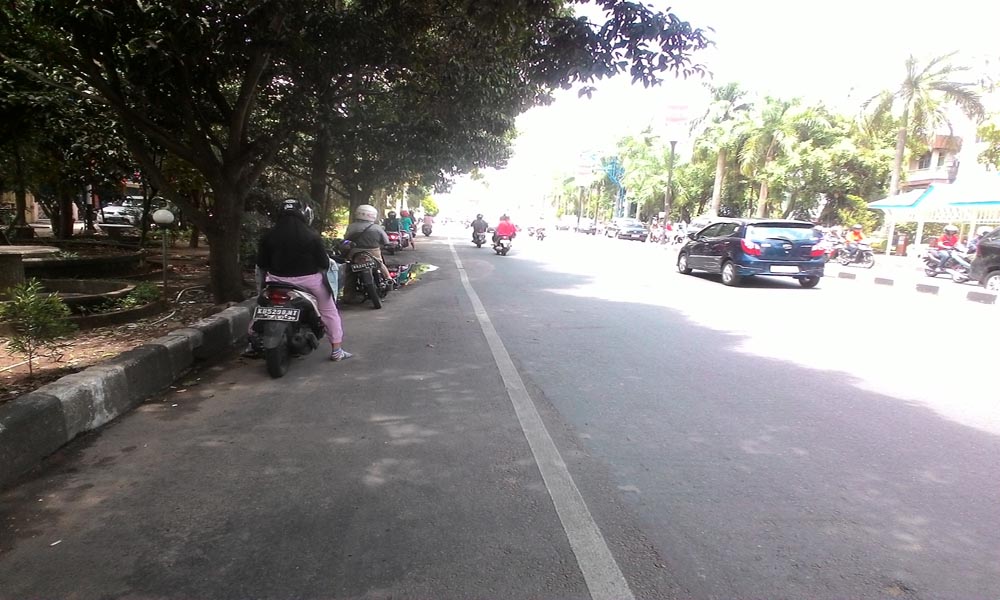 Pengendara Motor ini Berteduh di Ruas Jalan yang Tak Diperbolehkan