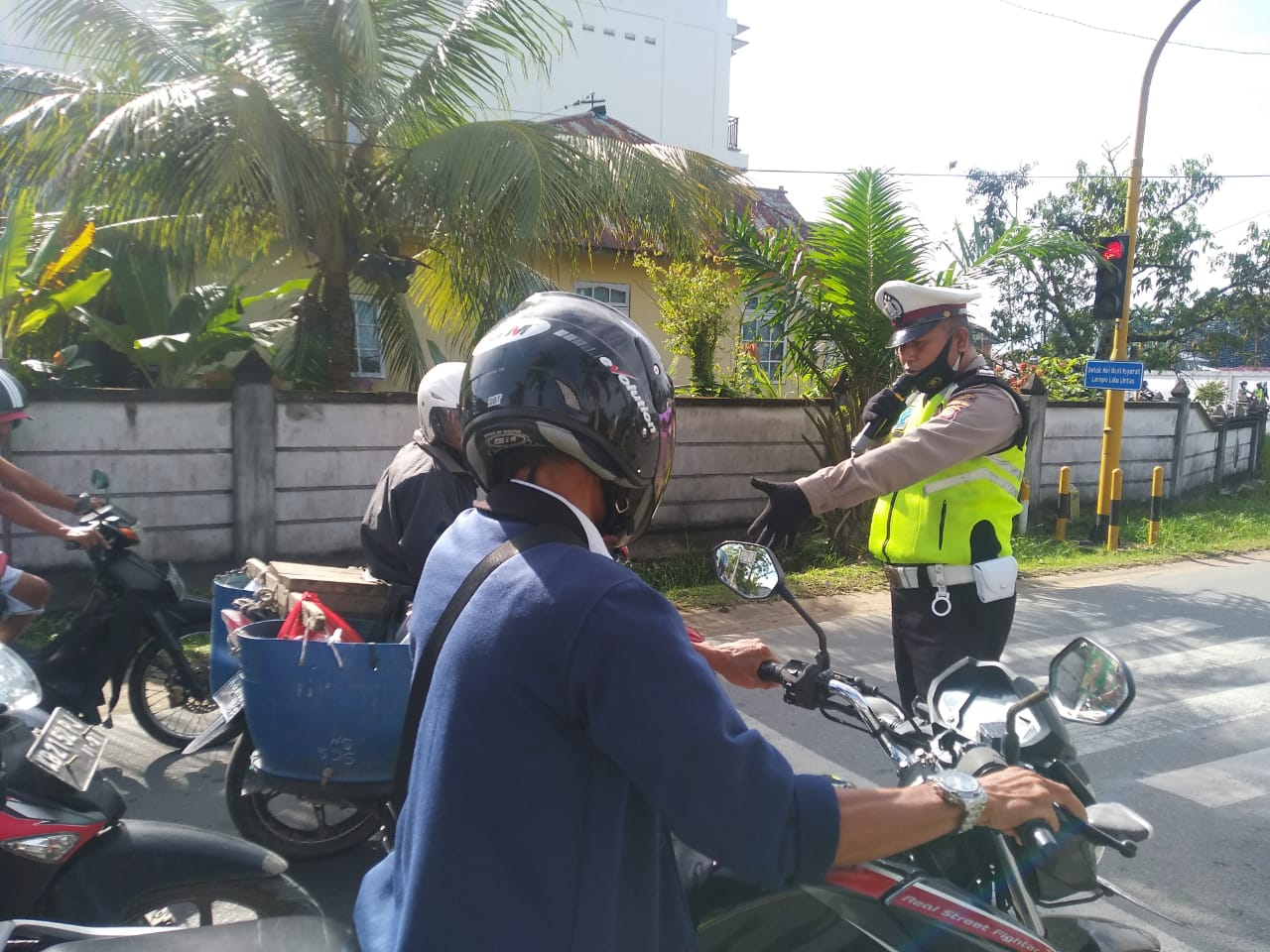 Satlantas Sampaikan Imbauan Disiplin Protokol Kesehatan pada Pengendara Bermotor di Traffic Light