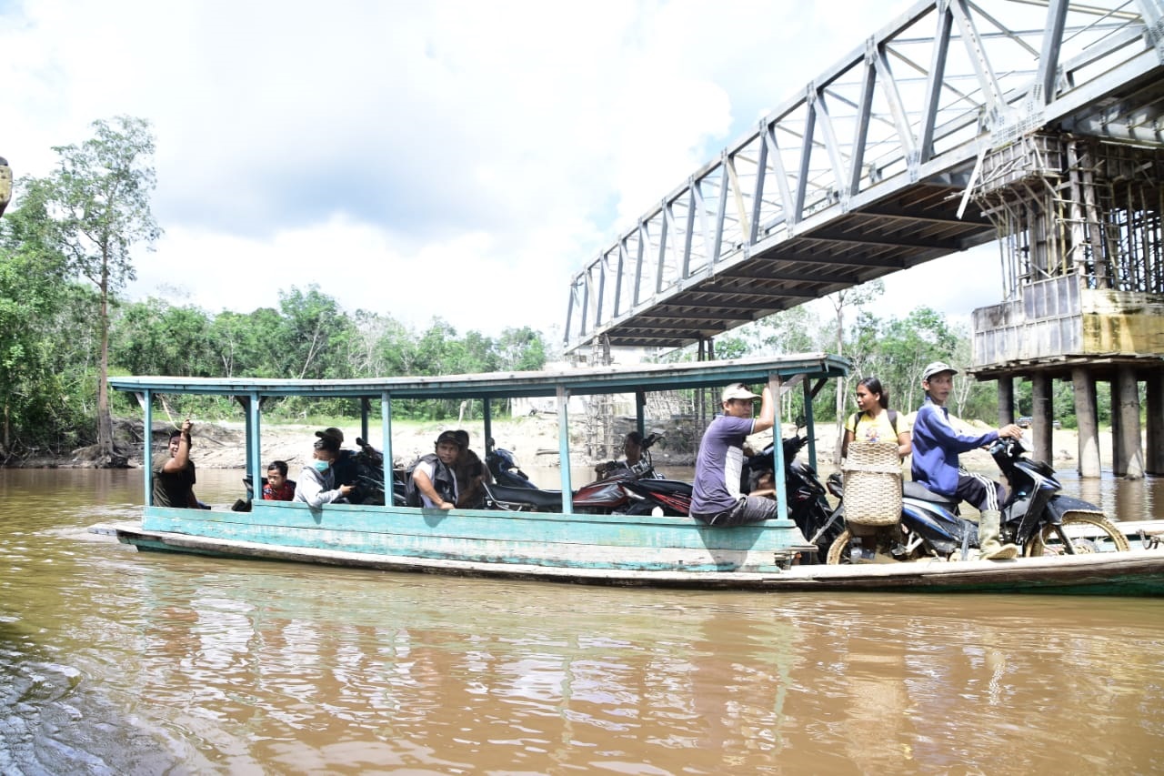 sejumlah-warga-menyebrangi-sungai-menggunakan-perahu.jpg