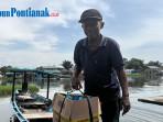 Amri-seorang-penambang-sampan-jasa-penyeberangan-di-sungai-Sambas.jpg