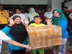 Seorang-siswa-SD-Kecamatan-Sebawi-didampingi-orangtuanya-menerima-hadiah.jpg