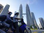 pengendara-yang-mengenakan-masker-menunggu-di-depan-menara-kembar.jpg