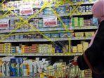 seorang-pembelanja-berjalan-melewati-produk-prancis-yang-disegel-di-balik-penutup-plastik.jpg