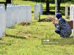 seorang-wanita-berziarah-kubur-ke-makam-keluarganya.jpg