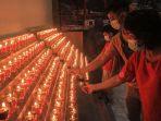 warga-keturunan-tionghoa-menghidupkan-lilin.jpg