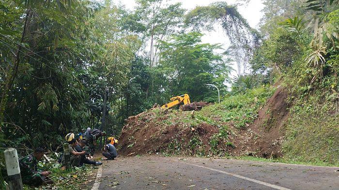 SINGKIRKAN MATERIAL LONGSOR - Satu ekskavator dikerahkan ke lokasi untuk membersihkan material longsor yang menutup jalan utama yang menghubungkan Kabupaten Sumedang dan Kabupaten Subang. Peristiwa tanah longsor tersebut terjadi di kawasan Wargaluyu, Kecamatan Tanjungmedar, Rabu (5/11/2025) dini hari.