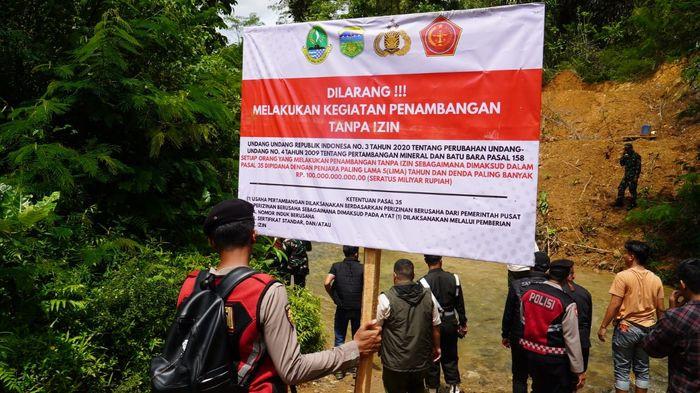 PASANG SPANDUK LARANGAN - Tim gabungan TNI Polri dan Satpol PP Kabupaten Tasikmalaya memasang spanduk larangan aktivitas tambang emas ilegal di Blok Cipanawar, Desa Mandalahayu, Kecamatan Salopa, Kabupaten Tasikmalaya, Kamis (13/11/2025).