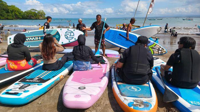 PADDLEBOARD - Wahana olahraga paddleboard yang menjadi satu aktivitas favorit banyak diburu pengunjung di kawasan Pos 1 Pantai Barat Pangandaran, Sabtu (30/5/2026) pagi.